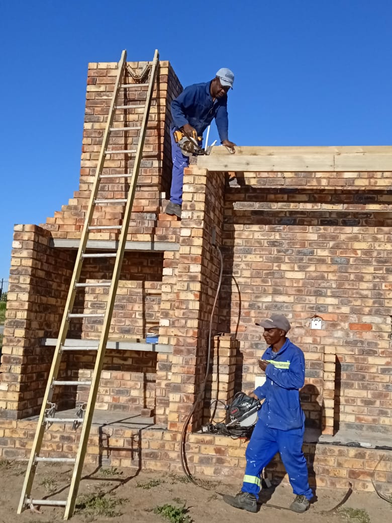 Dee Builders crew framing a roof structure on a brick build